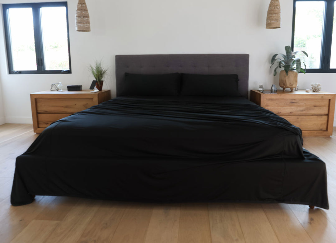 Black sheet set shown on bed in bedroom environment. #choose-your-color_black