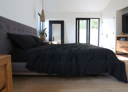 Black sheet set shown on bed in bedroom environment. #choose-your-color_black