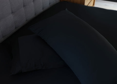 Black pillowcase set shown on bed in bedroom environment. #choose-your-color_black