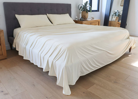 Ecru sheet set shown on bed in bedroom environment. #choose-your-color_ecru