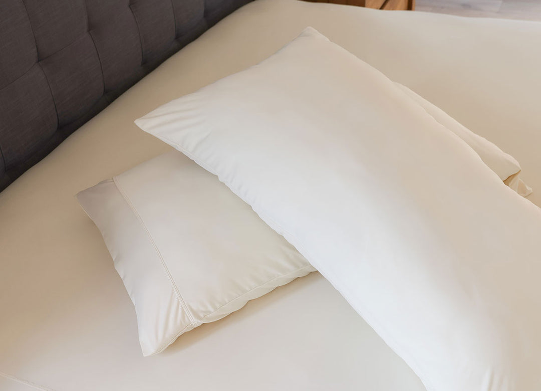 Ecru sheet pillowcase pair shown on bed in bedroom environment. #choose-your-color_ecru