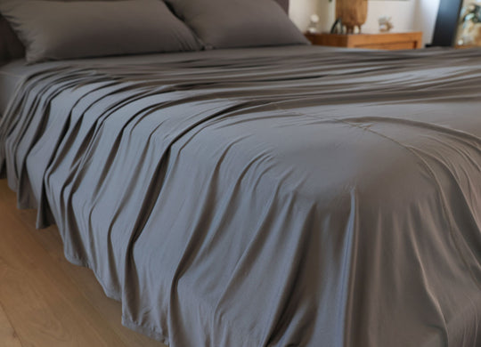 Graphite sheet set shown on bed in bedroom environment. #choose-your-color_graphite