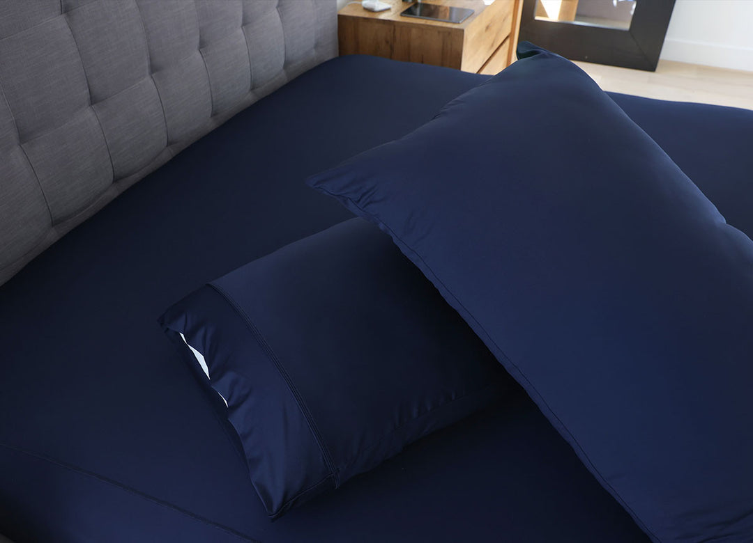 Navy Blue pillowcase set shown on bed in bedroom environment. #choose-your-color_navy