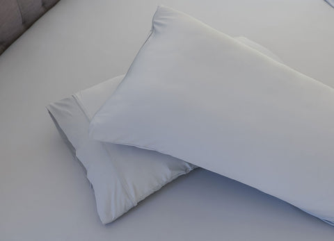 Pearl Blue pillowcase set shown on bed in bedroom environment. #choose-your-color_pearl-blue